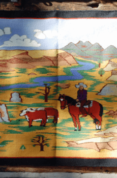 A vibrant woven tapestry depicting a cowboy on horseback herding cattle in a colorful, mountainous landscape.
Product Name: Revival