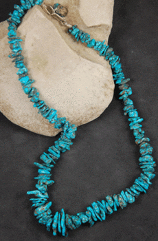 Natural Red Mountain Turquoise Nugget Necklace displayed on a gray stone background.