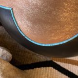 Close-up of a clay pot with turquoise inlay.