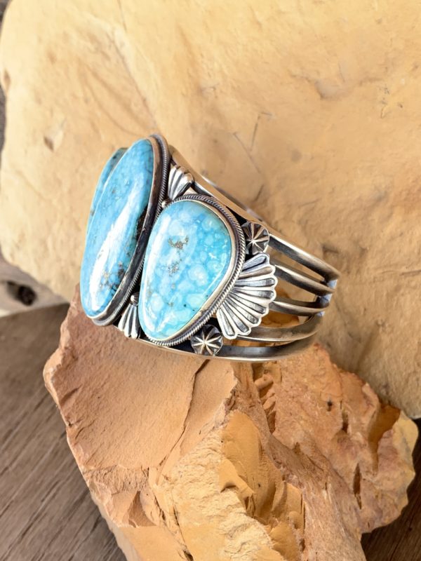 A close up of a silver bracelet with two blue stones