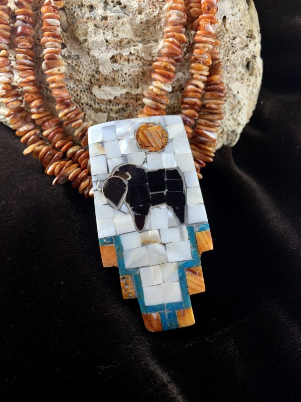 A mosaic necklace with an animal on it.