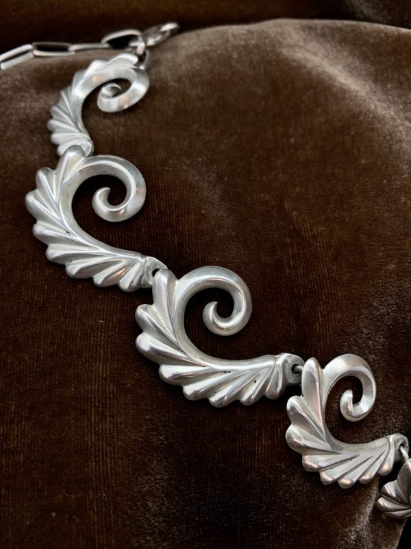 A close up of the silver ornament on a brown cloth