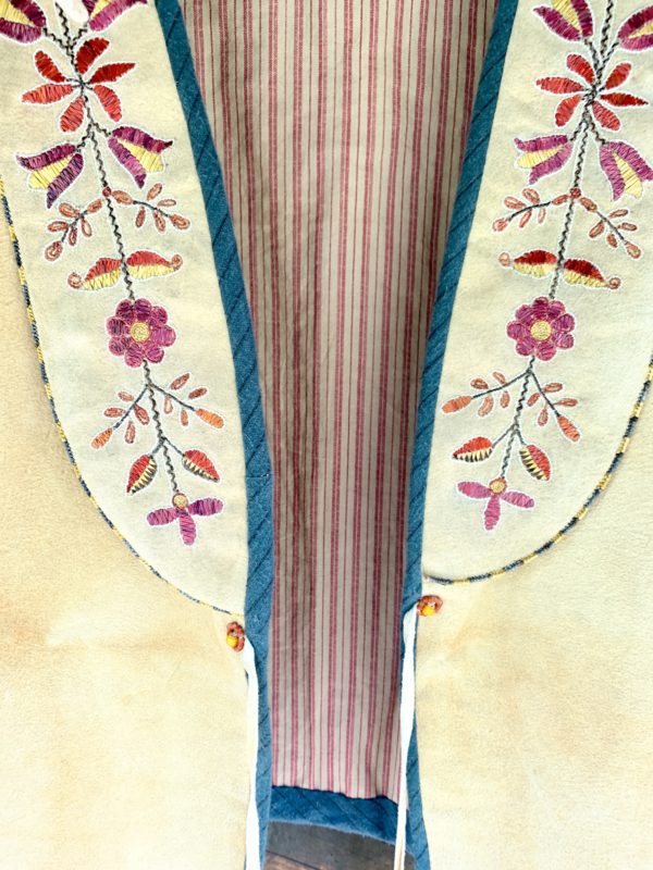 A close up of the front of an embroidered dress.