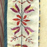 A close up of the embroidered design on a scarf.