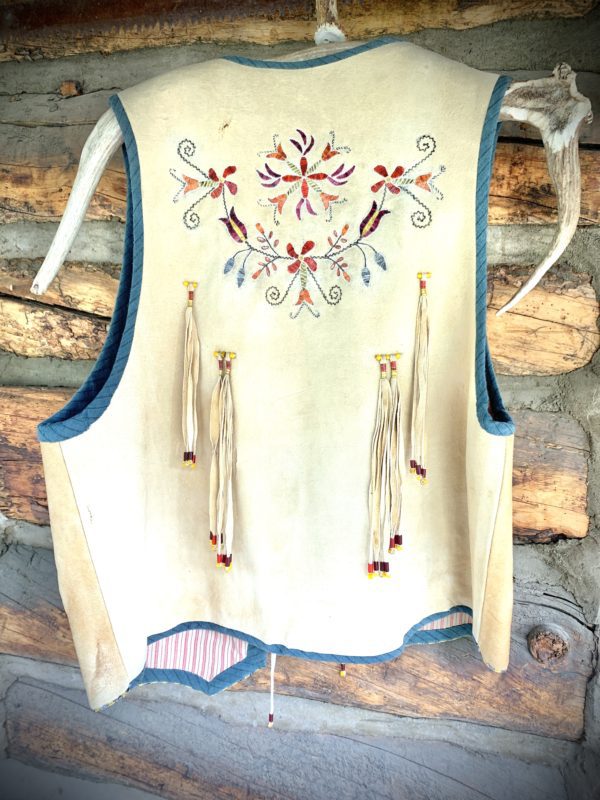 A vest with blue trim and white flowers.