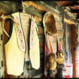 A bunch of native american clothing hanging on the wall.