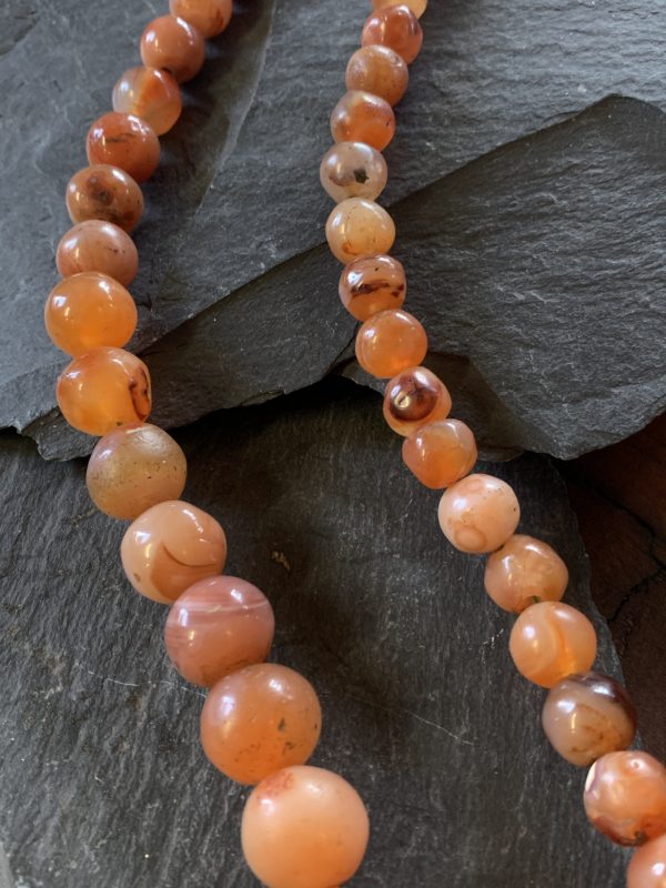 A close up of an orange bead necklace