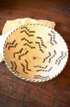 A basket on the floor with some cloth