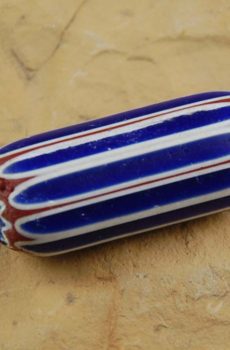 A blue and white striped bead sitting on top of a table.
