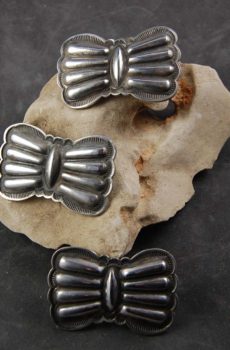 A group of three silver bow tie shaped rings.