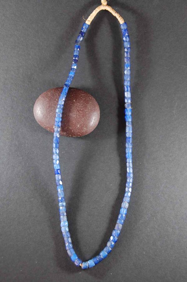 A wooden bead and blue beads on a black background