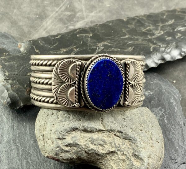 A silver bracelet with a blue stone on it.