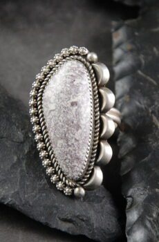 A silver ring with a large stone on top of it.