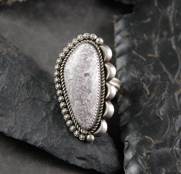 A silver ring with a large stone on top of it.
