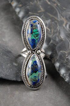 A silver ring with two blue and green stones.