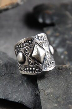 A silver ring sitting on top of some rocks.
