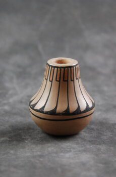 A small vase with black and white designs on it.