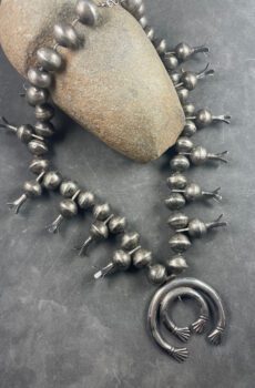 A necklace with an old silver ring and some beads
