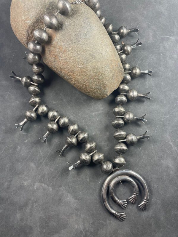 A necklace with an old silver ring and some beads