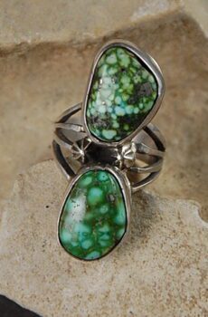 A ring with two green stones on it