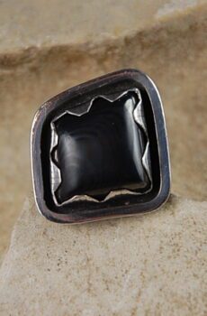 A black square ring sitting on top of a rock.