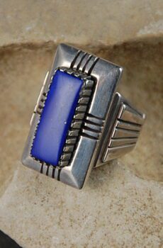 A silver ring with blue stone on top of it.