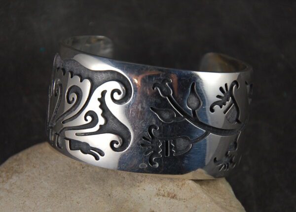 A silver bracelet with a design on it.