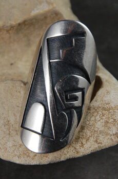 A silver ring with an abstract design on it.