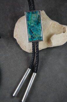 A bolo tie with a turquoise stone on it.