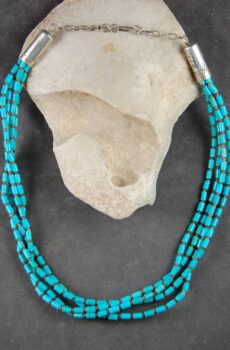 A necklace of three strands of turquoise beads.