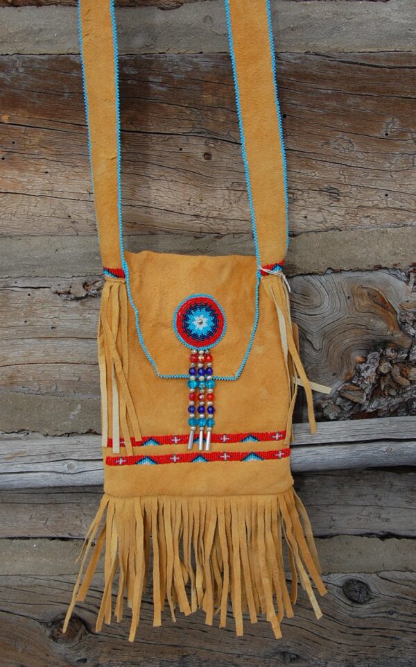 A bag with a fringed bottom and beads on it.