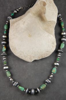 A necklace of green turquoise and silver beads.