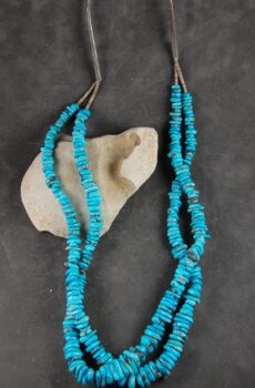A close up of two necklaces on a rock