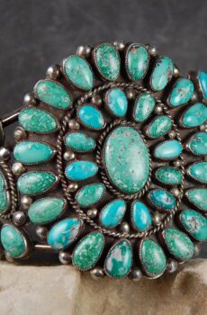 A close up of the turquoise bracelet on a rock