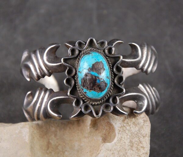 A silver bracelet with turquoise on top of it.