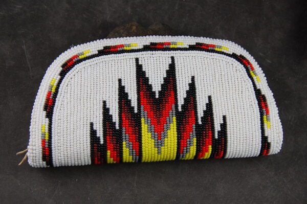 A white purse with red, yellow and black flames.