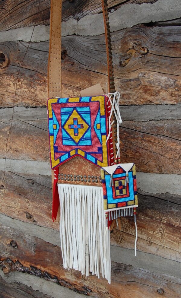 A colorful wooden wall hanging with a white fringe.