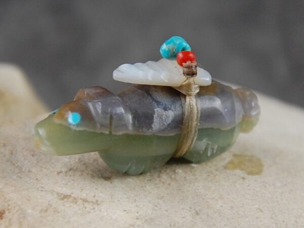 A small turtle with a turquoise bead on its head.