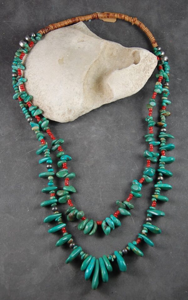 A long necklace of turquoise and red coral.