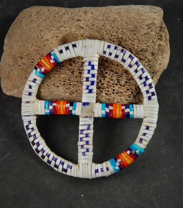 A white and blue cross shaped object with beads.