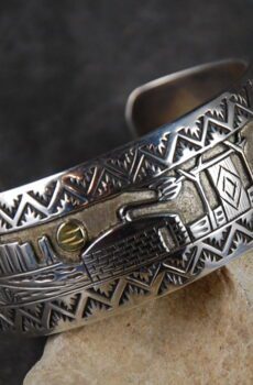 A silver bracelet with an eagle on it.