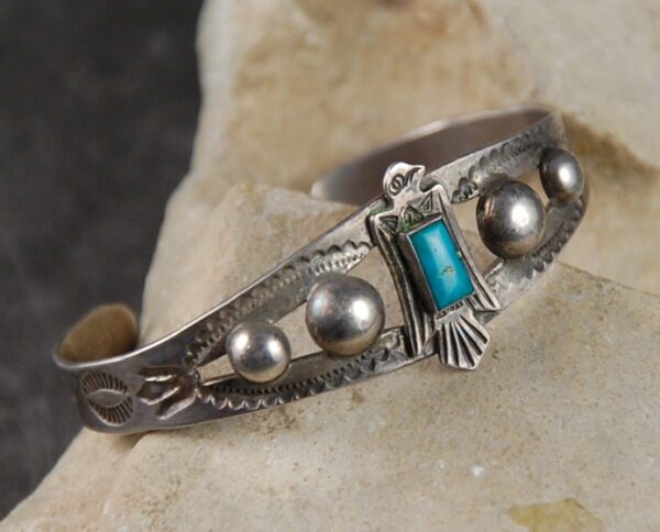 A close up of an old silver bracelet