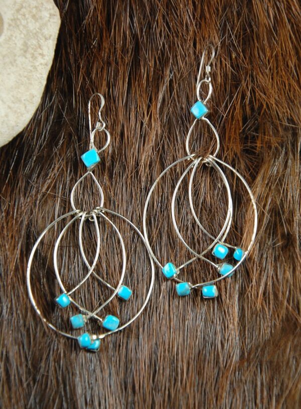 Silver hoop earrings with turquoise stones.